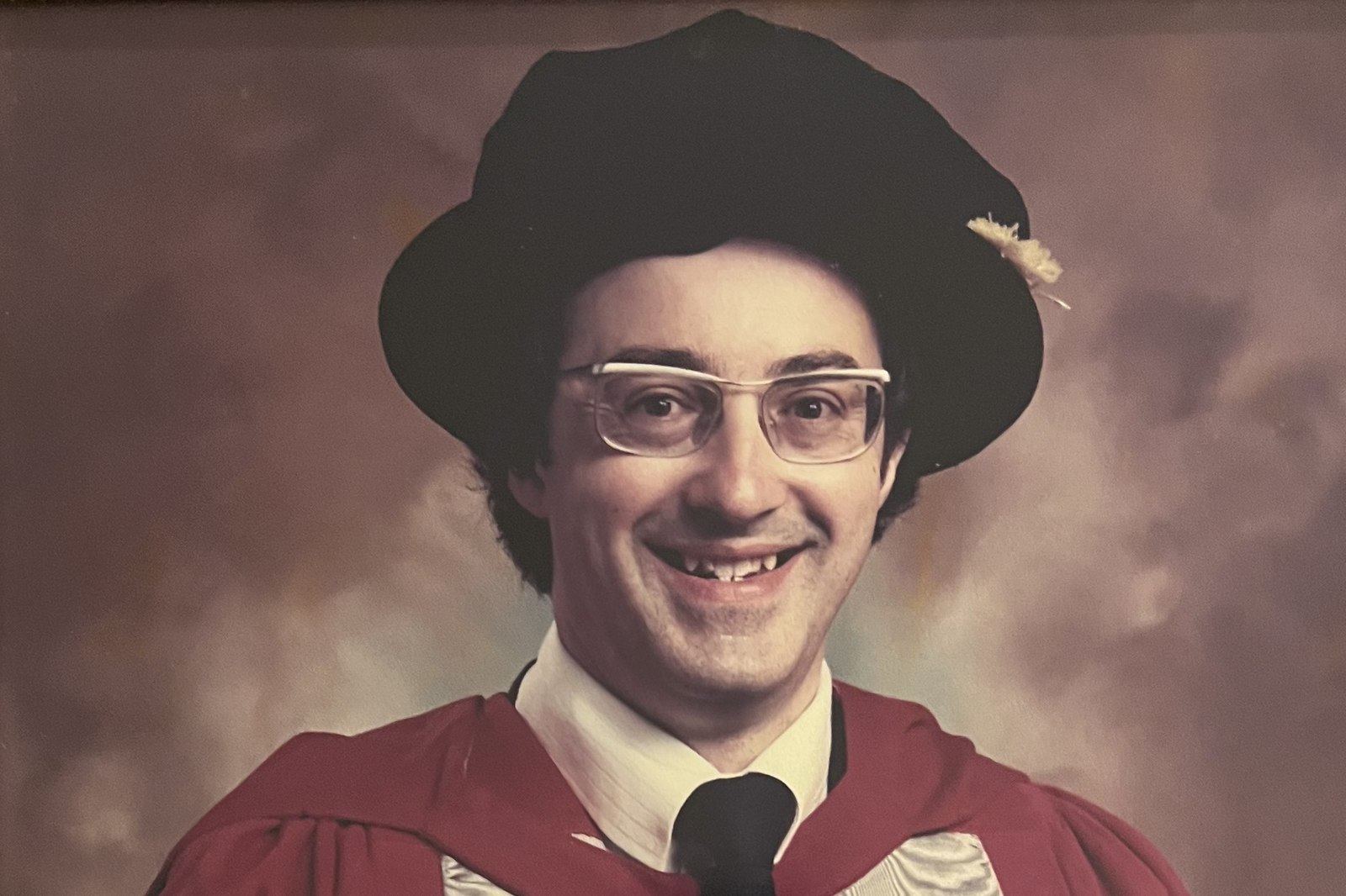 Mike Grimble in academic dress with his doctoral scroll